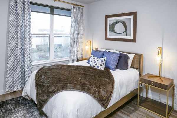 Cozy bedroom with modern furnishings at Waterline Apartments, offering luxurious living spaces in a Greystar luxury community