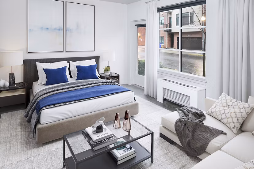 Tranquil bedroom with modern furnishings at Waterline Apartments, featuring floor-to-ceiling windows for natural light