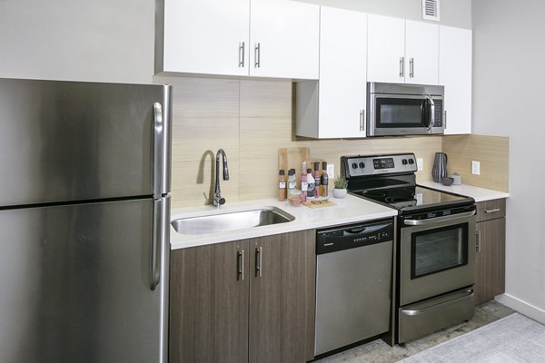 Modern kitchen featuring stainless steel appliances at Waterline Apartments