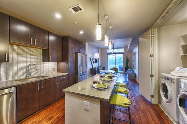 Modern kitchen with granite countertops at One Hermann Place Apartments