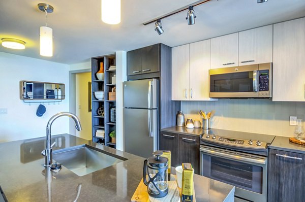 Modern kitchen with sleek countertops and stainless steel appliances at Adaire Apartments