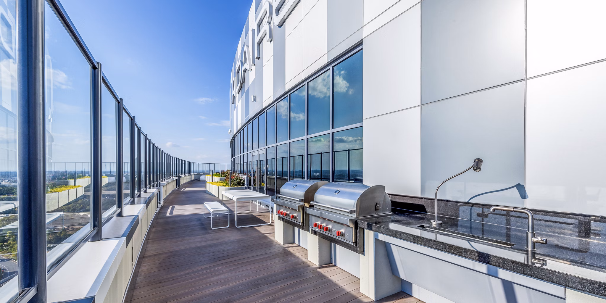 Grill area with modern patio seating at Adaire Apartments, perfect for outdoor entertaining in a luxury setting