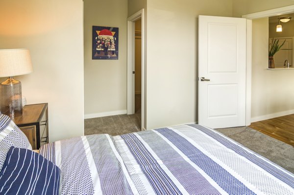 Cozy bedroom with modern furnishings at North Bethany Ridge Apartments, a luxury Greystar property