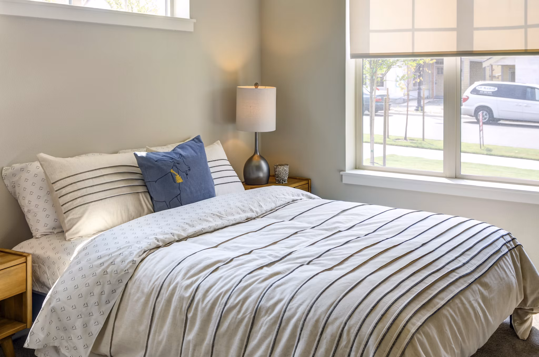Cozy bedroom with large windows and modern decor in North Bethany Ridge Apartments