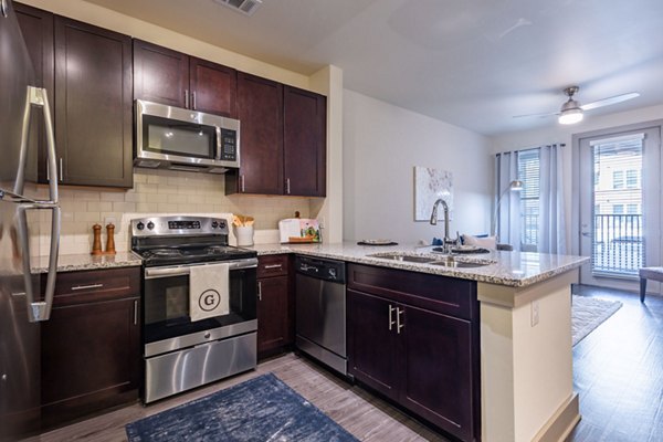 Sleek kitchen with stainless steel appliances in The Gramercy Apartments