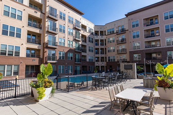 Outdoor patio with modern seating and lush landscaping at The Gramercy Apartments