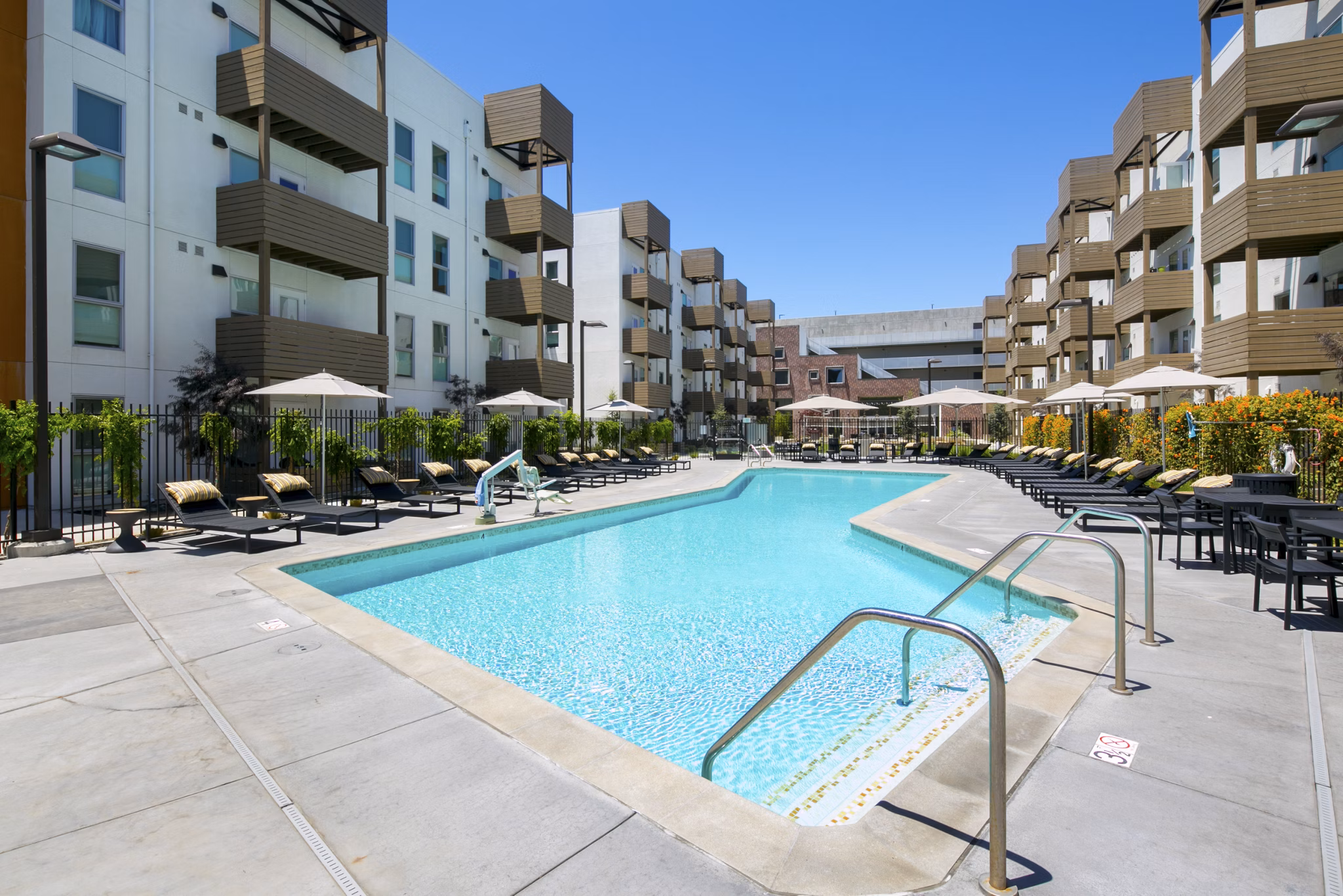 Modern outdoor pool with lounge chairs at Foundry Commons Apartments