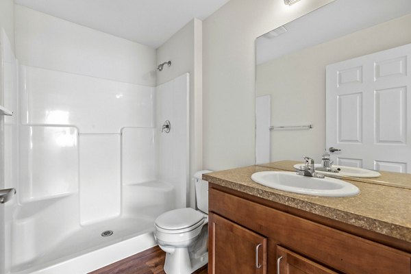 Modern bathroom with sleek fixtures at Carrington Place Apartments, featuring a spacious vanity and elegant tile flooring