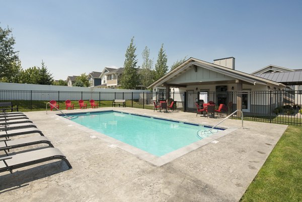 Resort-style swimming pool at Villas at Tullamore Apartments with lounge chairs and lush landscaping