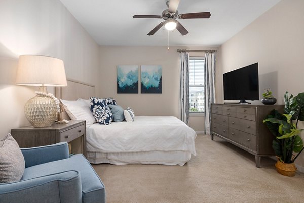 Bedroom at Bridgeside at Patriots Point Apartments: Cozy bedroom with modern decor and ample natural light, luxury living by Greystar