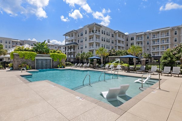 Resort-style pool with lounge chairs at Bridgeside at Patriots Point Apartments