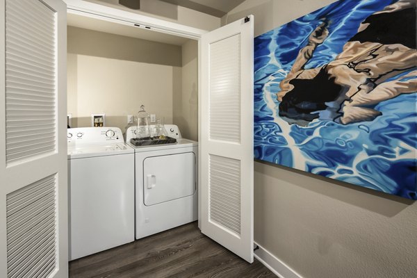 Laundry room with modern appliances at Luxe Pasadena Apartments