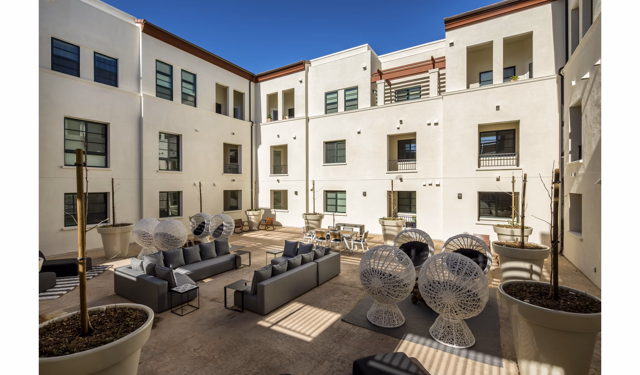 Luxe Pasadena Apartments: Serene courtyard with lush greenery and seating areas in prime Pasadena location