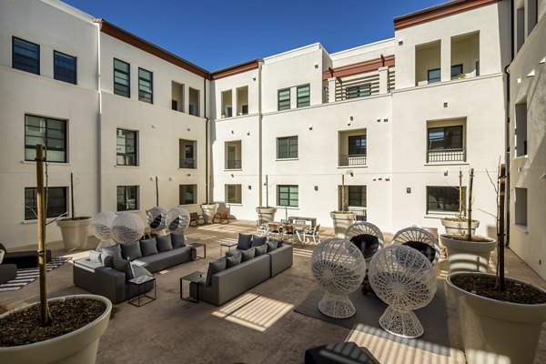 Luxe Pasadena Apartments: Serene courtyard with lush greenery and seating areas in prime Pasadena location