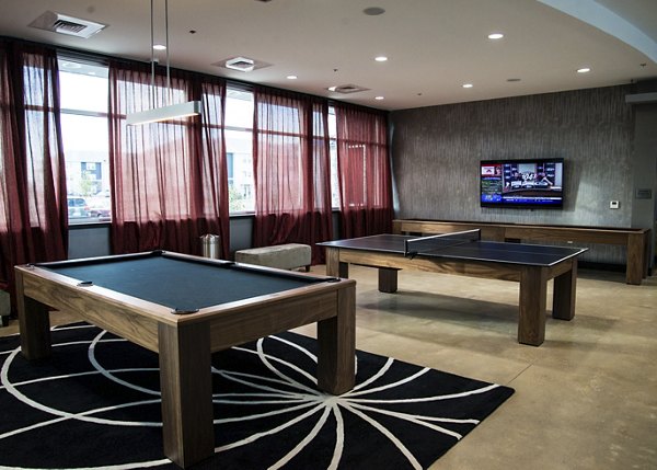 Modern game room with pool table and lounge seating at The Ave at Norman Apartments