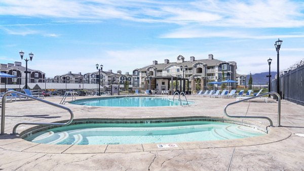 Resort-style pool with lounge chairs at Bay Court at Harbour Pointe Apartments, featuring luxury amenities and stunning water views