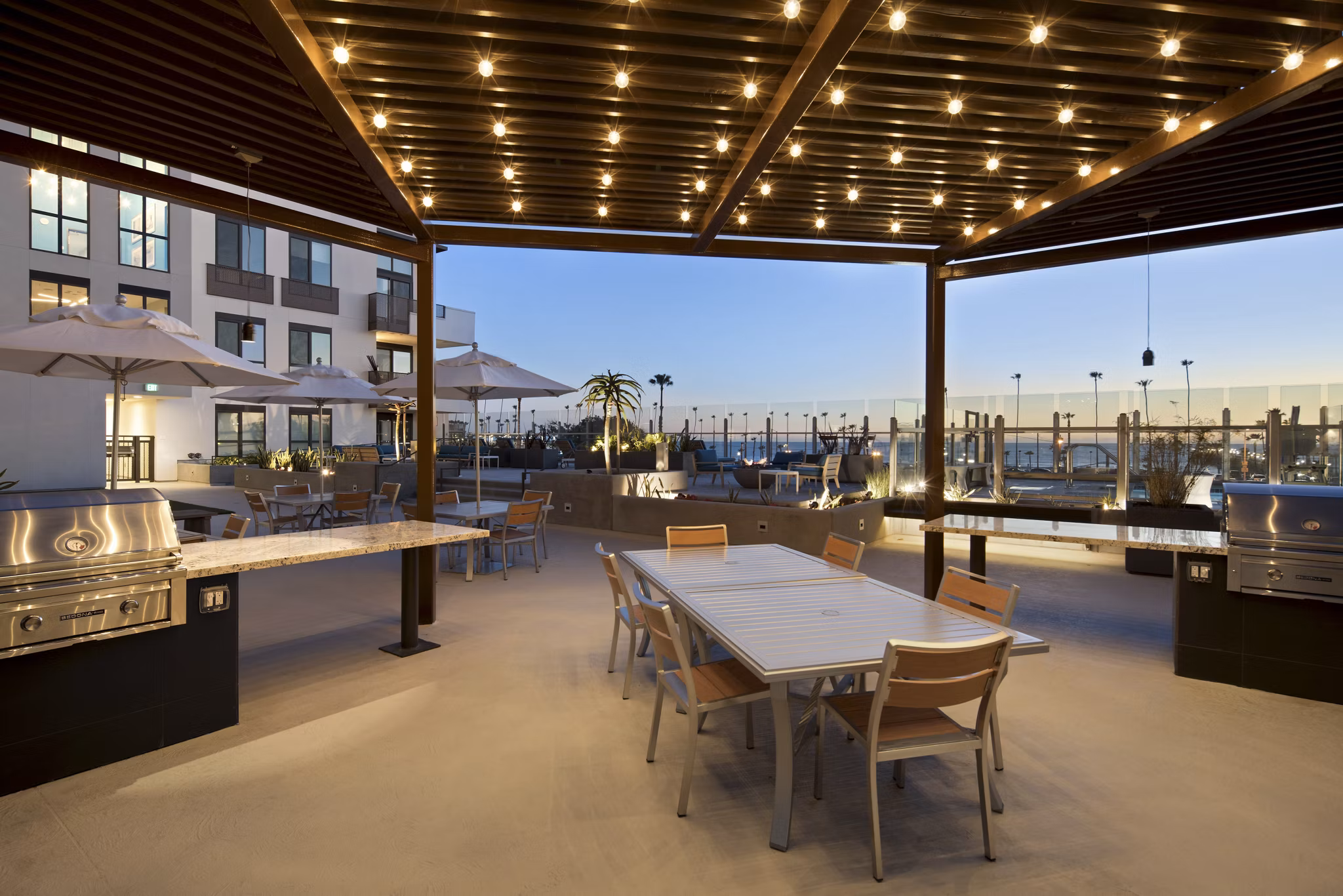 Grill area with modern seating at Pierside Apartments, offering outdoor cooking facilities and social space