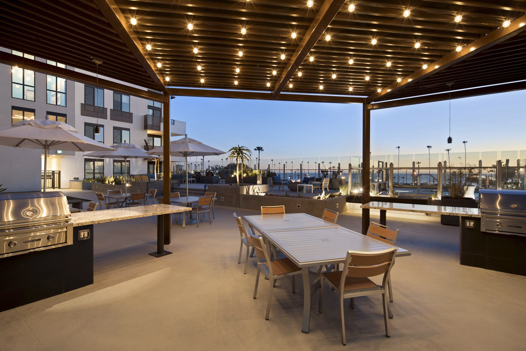 Grill area with modern seating at Pierside Apartments, offering outdoor cooking facilities and social space