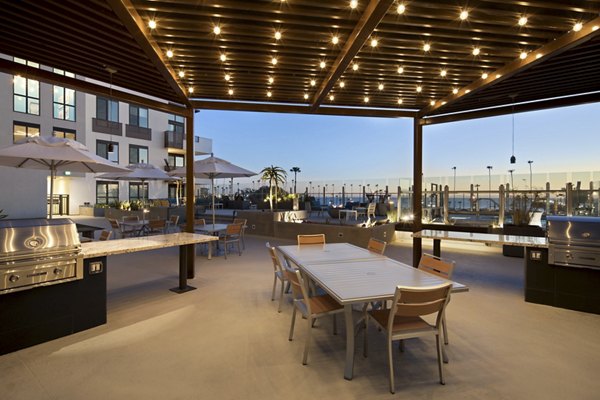 Grill area with modern seating at Pierside Apartments, offering outdoor cooking facilities and social space
