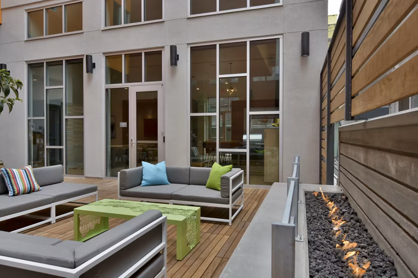 Stylish patio area at Parker Apartments with modern outdoor furniture and lush greenery, ideal for relaxation and social gatherings