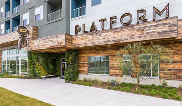 Building with "PLATFORM" sign and greenery on walls at Platform Apartments