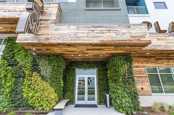 Building entrance with green wall and wooden overhang at Platform Apartments