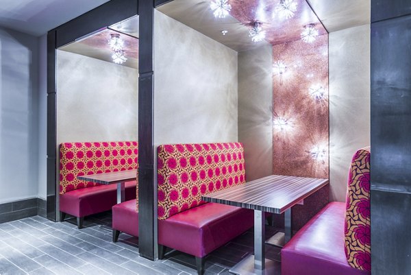 Modern restaurant booth with red patterned seating and lighting at Platform Apartments