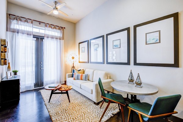 Bright living room with white sofa and dining table at Platform Apartments