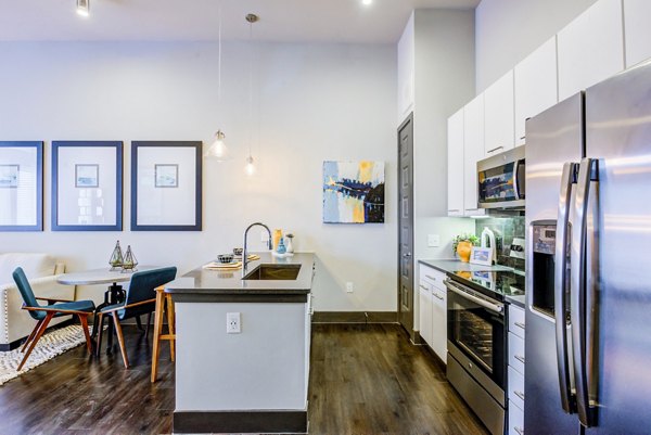 Bright kitchen with stainless steel appliances and island in Platform Apartments