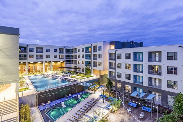 Apartment complex with pool, hot tubs, and outdoor seating area at Platform Apartments