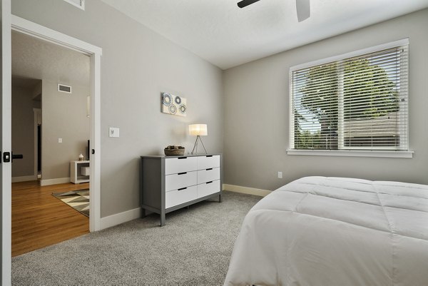 Cozy bedroom featuring elegant furnishings and natural lighting in Rosewood Apartments, offering premium living spaces