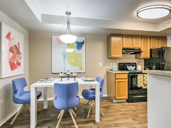 Dining room with elegant chandelier and modern furnishings at Rosewood Apartments