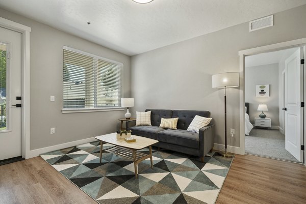 Contemporary living room with stylish decor and ample natural light at Rosewood Apartments