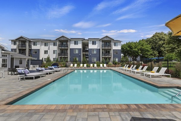 Refreshing blue-tiled pool surrounded by lush landscaping at Rosewood Apartments