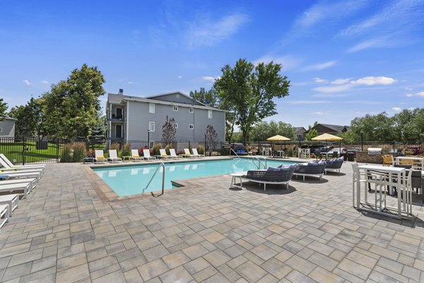 Luxurious poolside area at Rosewood Apartments with loungers and lush landscaping for a relaxing experience