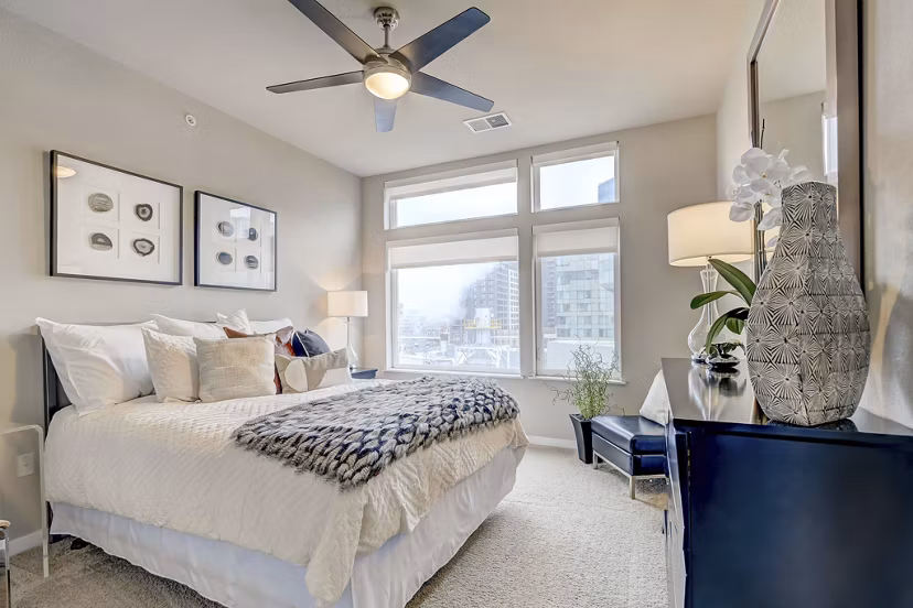 Cozy bedroom with elegant bedding and natural light at Alara Union Station Apartments