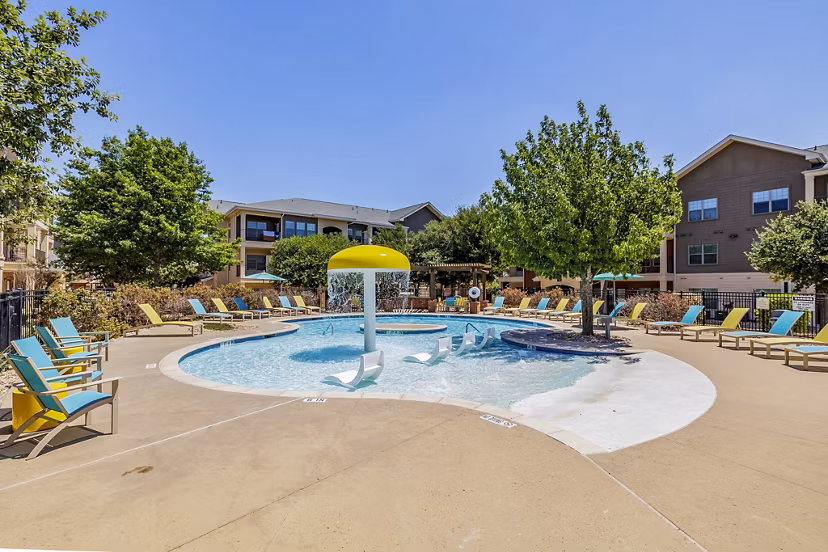 Outdoor pool area with luxurious lounge chairs at The Dorel, Girard Court Apartments, offering a relaxing retreat for residents