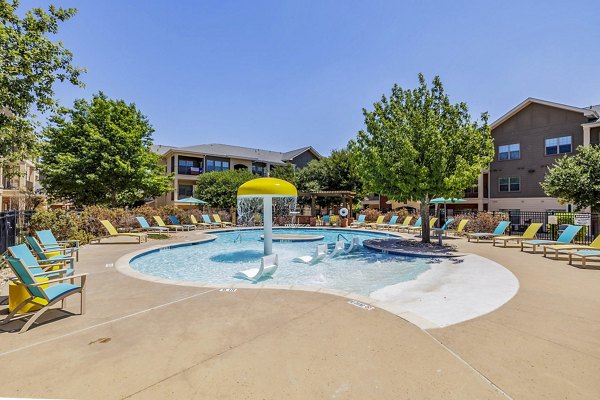 Outdoor pool area with luxurious lounge chairs at The Dorel, Girard Court Apartments, offering a relaxing retreat for residents