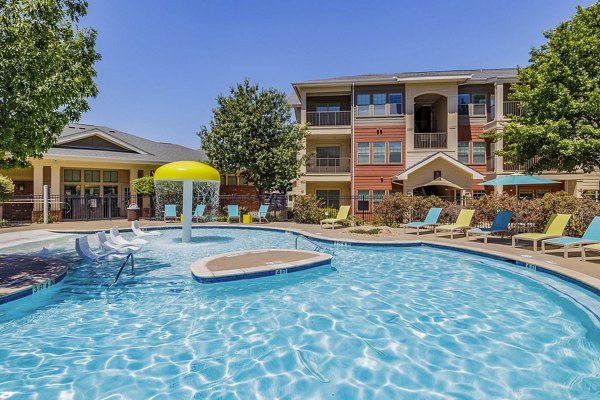 Inviting pool area at The Dorel/Girard Court Apartments with lounge seating and lush landscaping