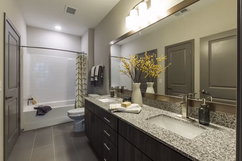 Modern bathroom with sleek fixtures and elegant marble countertops at Anderson Flats Apartments