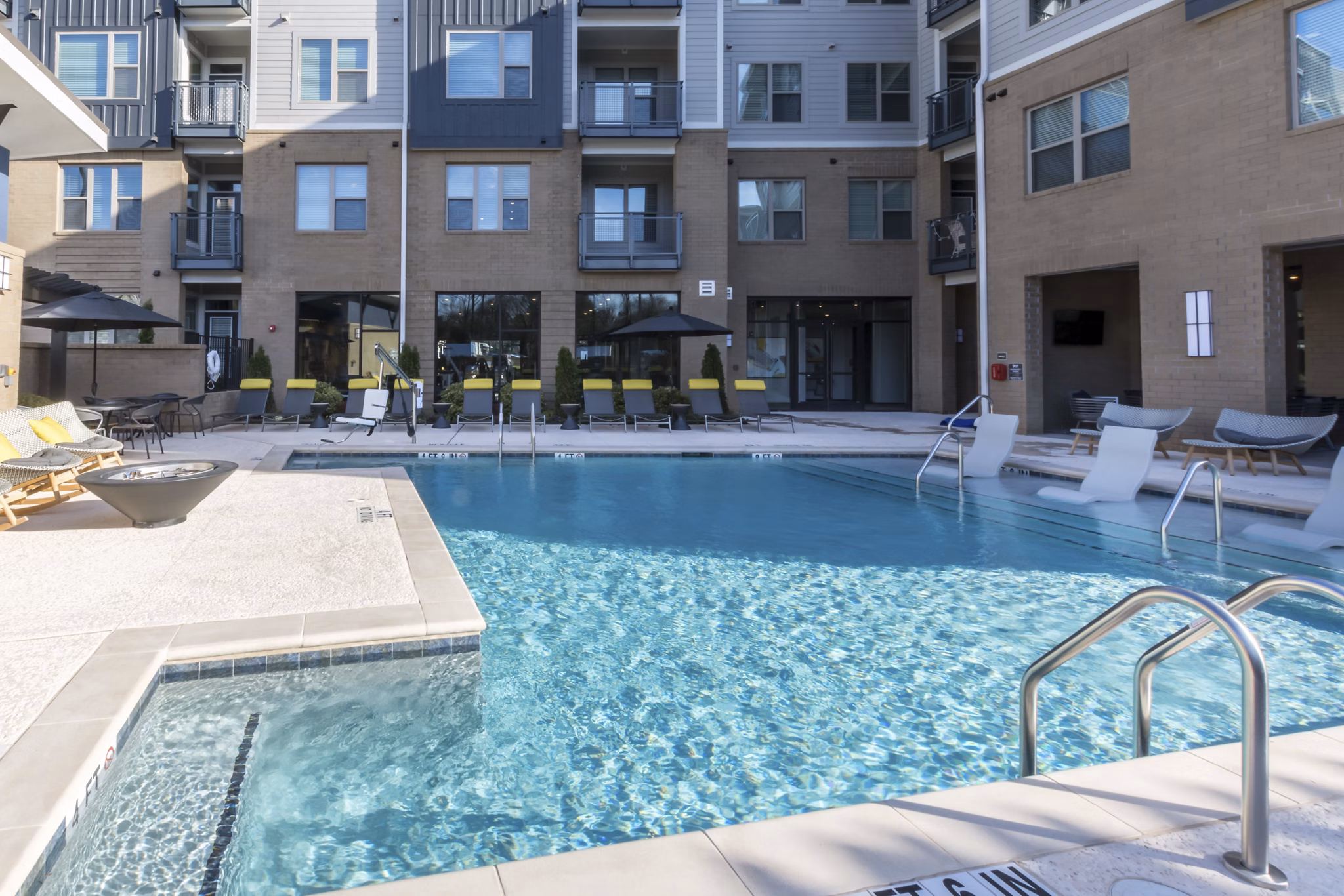 Resort-style pool with modern loungers at Anderson Flats Apartments