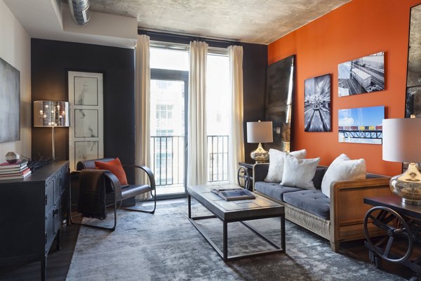 Contemporary living room with stylish decor and natural light at Anthology Apartments