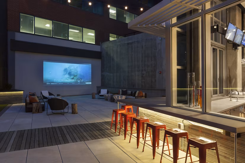 Outdoor patio area with modern seating and greenery at Anthology Apartments, offering a relaxing communal space for residents