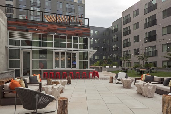 Patio area with modern seating and string lights at Anthology Apartments, a luxury Greystar community