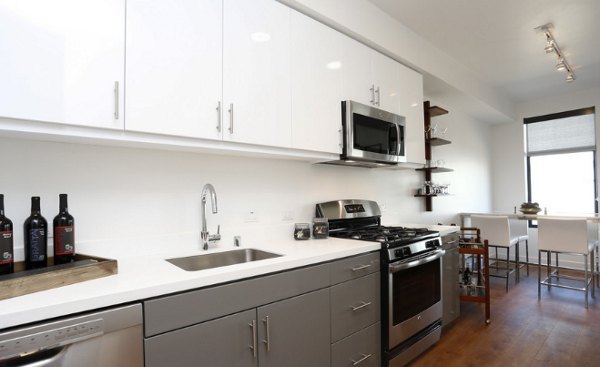 Modern kitchen with stainless steel appliances and marble countertops at Waterbend Apartments