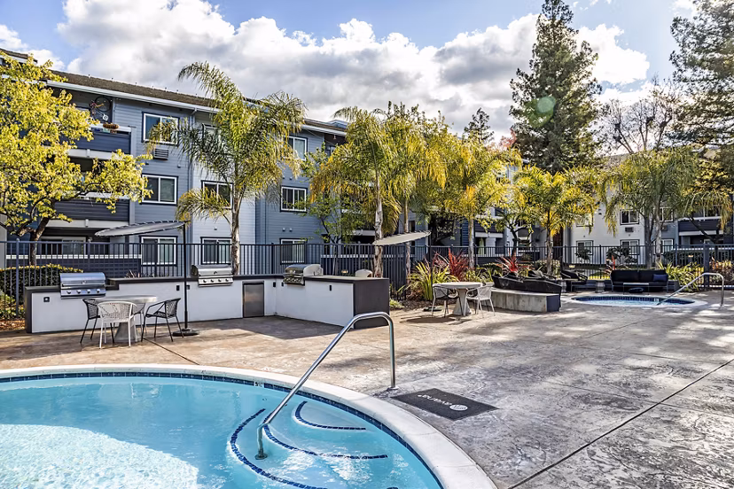 Resort-style pool at Avana Almaden Apartments with lounge chairs and greenery, perfect for relaxation in a luxury setting