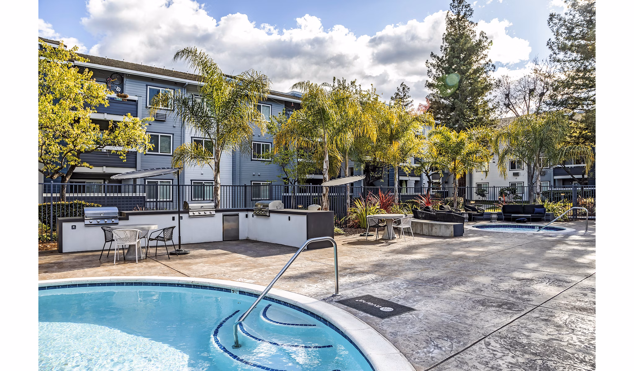 Resort-style pool at Avana Almaden Apartments with lounge chairs and greenery, perfect for relaxation in a luxury setting