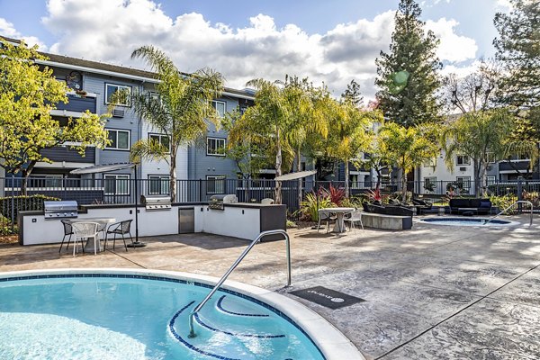 Resort-style pool at Avana Almaden Apartments with lounge chairs and greenery, perfect for relaxation in a luxury setting