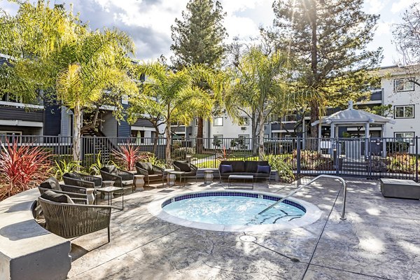 Outdoor hot tub at Avana Almaden Apartments with lush greenery surroundings for a relaxing luxury experience