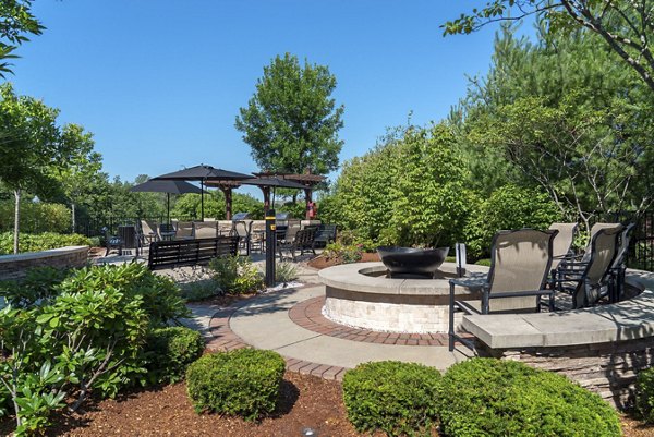 Cozy outdoor fire pit area at Lux at Stoughton Apartments, ideal for socializing and relaxation under the stars
